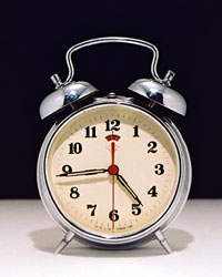 A silver alarm clock with bells.